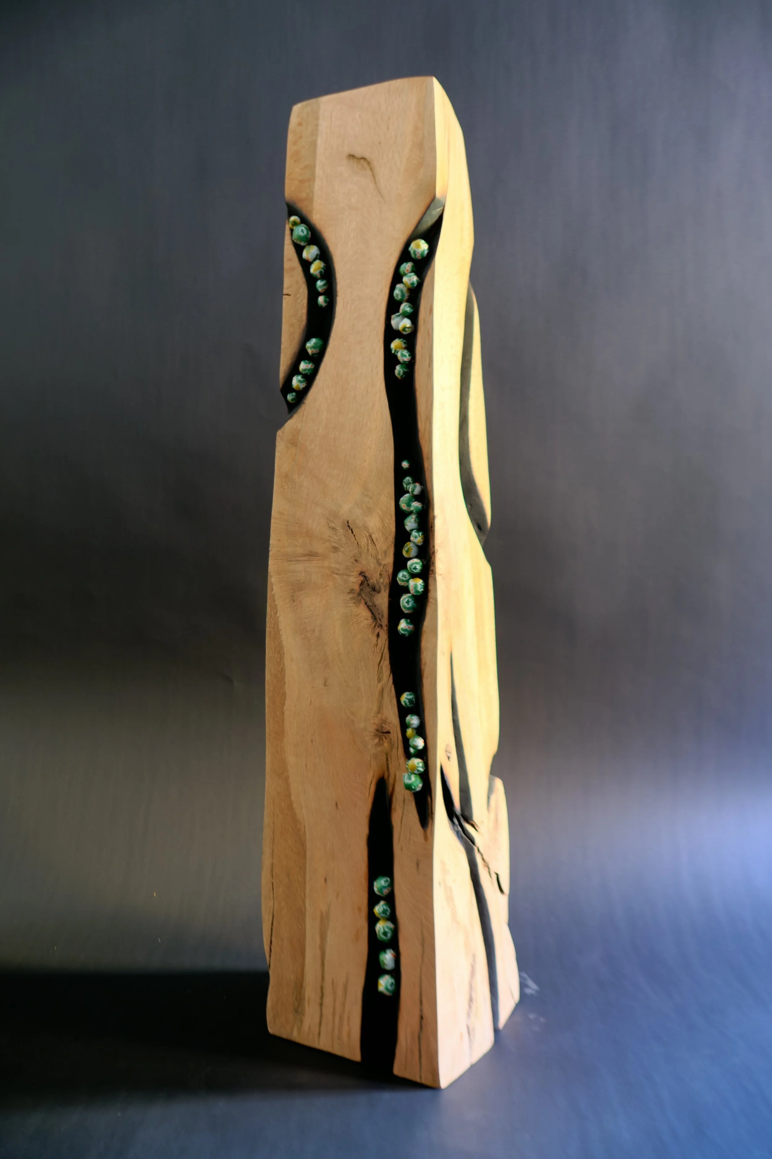 Kos Minar — a charred oak sculpture wrapped with fabric.