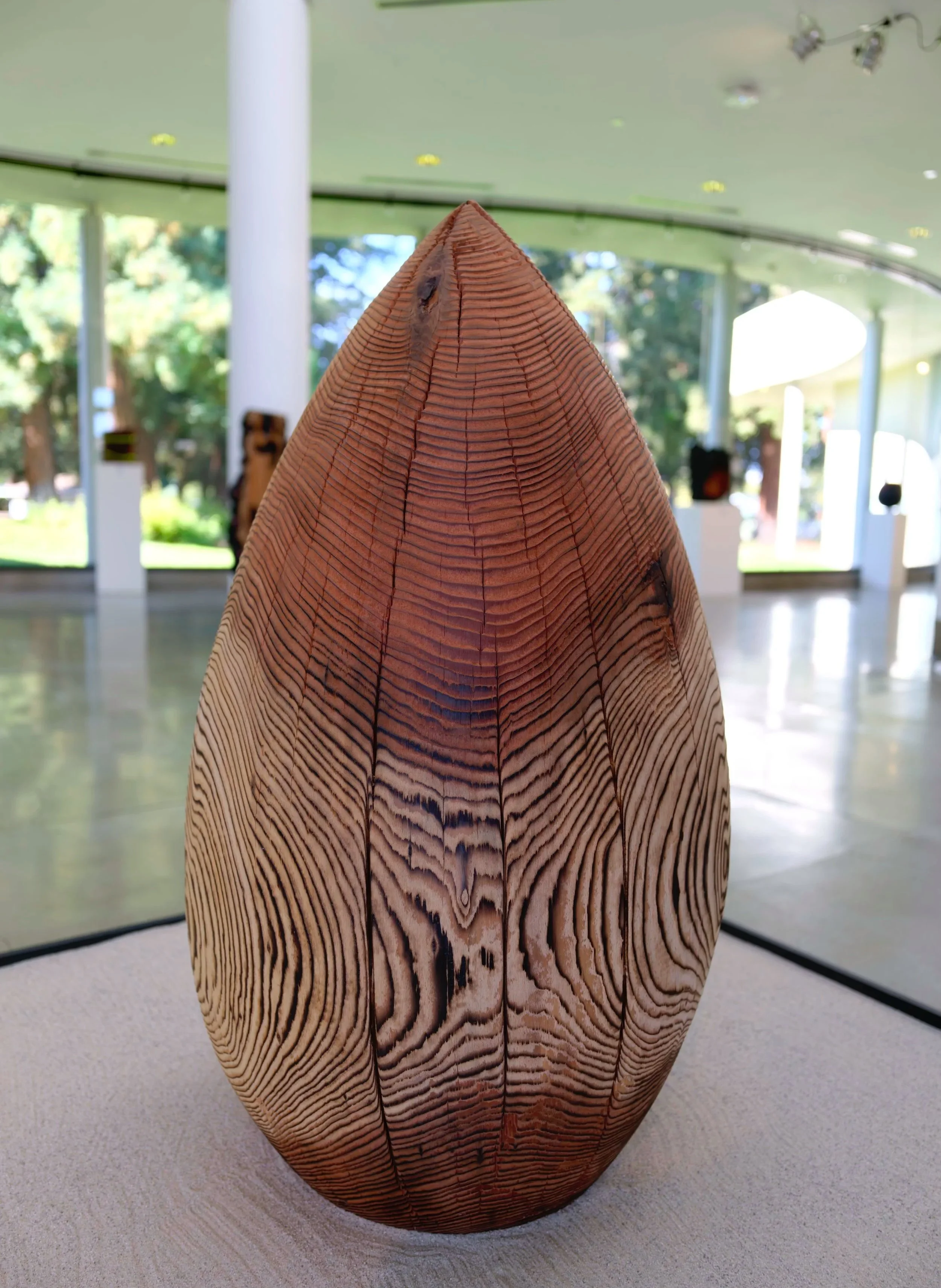 Monsoon — a charred redwood sculpture set with sand.