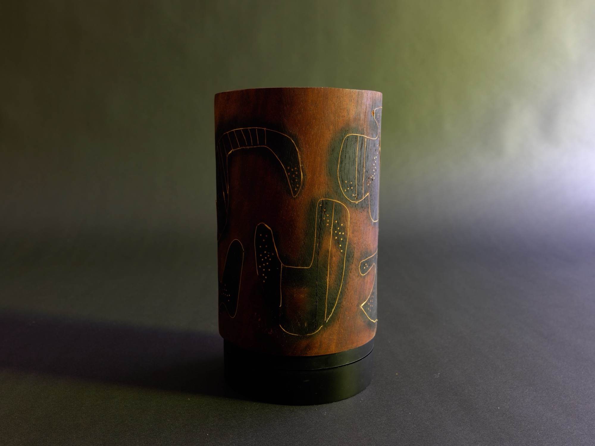 Dream, viewed horizontally — the carved wood form laid on its side, showing the length of its charred and rust-toned grain.